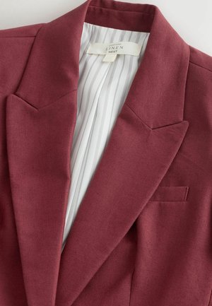Blazer din in burgundy cu guler cu revere și căptușeală internă albă cu dungi, afișând eticheta „Conține in NEXT”.