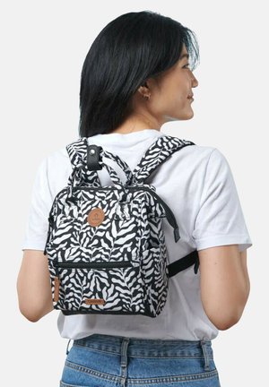 Rucksack im Zebra-Muster aus robustem Stoff, mit verstellbaren Trägern, einer vorderen Reißverschlusstasche und einem braunen Logo-Patch.