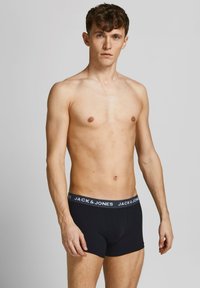 Schwarz Boxershorts aus dehnbarem Baumwollmaterial mit einem grauen Gummibund, der das "JACK & JONES"-Logo trägt. Glatte Textur, enganliegendes Design.