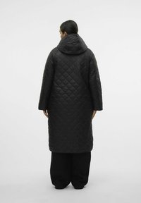 Gequilted zwarte lange jas met een capuchon, voorzien van brede mouwen en een strak ontwerp. De stof lijkt lichtgewicht met een gladde textuur.