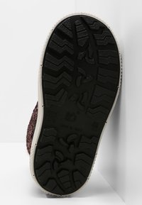 Sole of black rubber shoe with zigzag and propeller-shaped tread patterns, beige edging, labeled "Made in Italy," size 22/23.