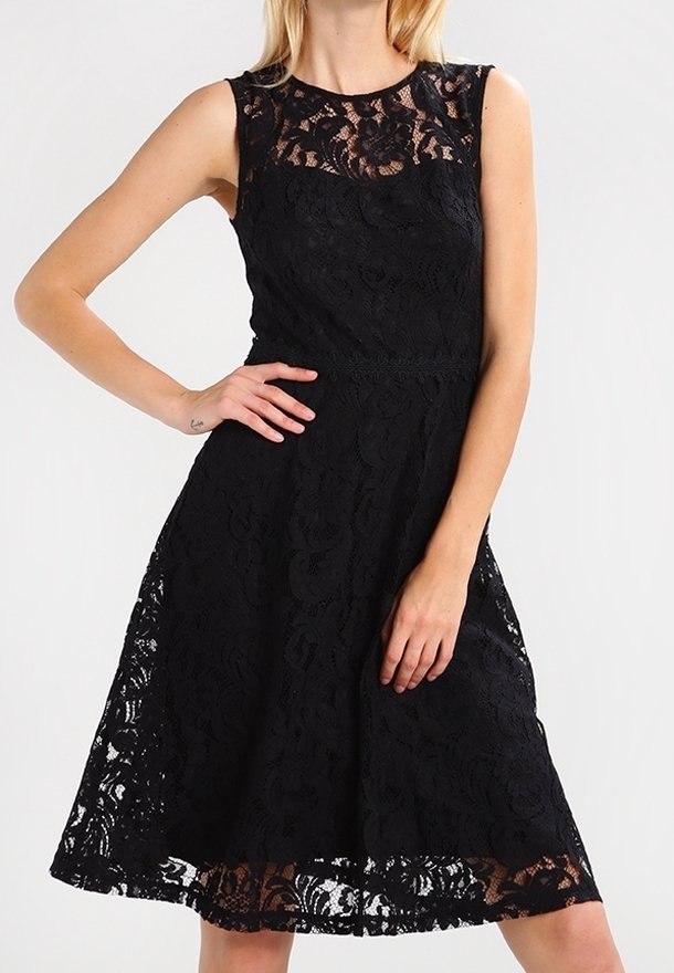 Svart spetsklänning med en åtsittande bodice och utfläkt kjol. Har ett genomskinligt spetsöverdrag och rund halsringning. Övre delen har blommönster.