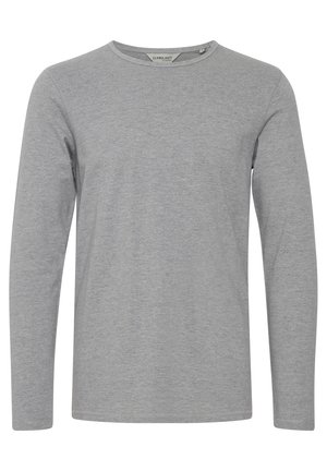 Pika pikkade varrukatega hall särk, mis on valmistatud pehmest kangast, ümara kaelusega ja lihtsa, seamatu disainiga. Pole nähtavaid mustreid ega aktsente.