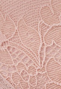 Różowa koronka z kwiatowymi wzorami, ozdobiona misternym haftem i miękką, teksturowaną powierzchnią. Widoczna delikatna siateczka i faliste krawędzie.