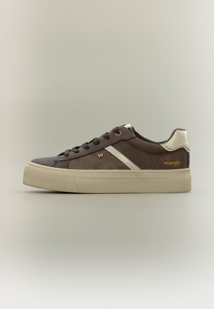 Baskets basses marron avec semelle beige, renfort talon beige, bande latérale, lacets noirs et logo Wrangler doré.