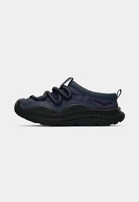 Ciemnoniebieskie sneakersy wsuwane z grubą czarną gumową podeszwą, okrągłą, wyściełaną cholewką, pętlą do ciągnięcia oraz grubym, spiralnym detalem sznurowadła.