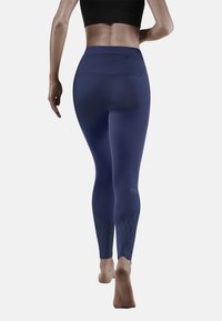 Die marineblauen Leggings verfügen über einen hohen Bund, eine glatte Textur und diamantförmige Akzente an den unteren Beinen, sowie einer verdeckten Gesäßtasche.