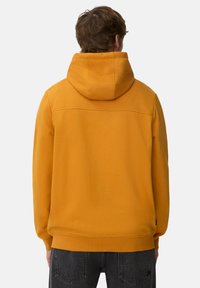 Sweat à capuche jaune avec une finition texturée, capuche ajustable avec cordon de serrage et poignets côtelés. La vue de dos montre une conception d'épaule sans coutures.