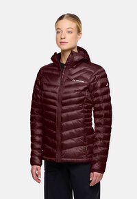 Bordeauxrode geïsoleerde jas met capuchon, voorzien van een verticaal doorgestikt ontwerp, ritssluiting aan de voorkant en logodetails op de borst en mouw.