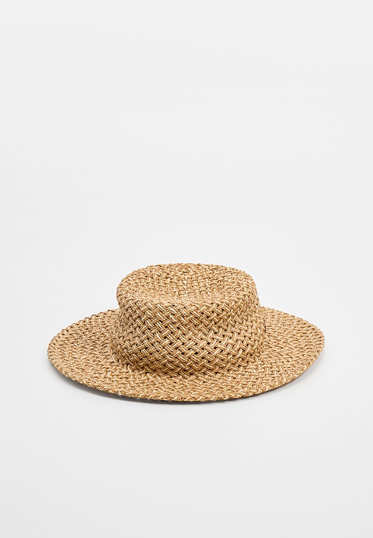 Geweven strohoed met een brede, platte rand en een cilinder-vormige kroon. Natuurlijke tan kleur met een gestructureerd patroon. Geen extra versieringen.