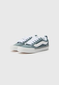 Vans kiitosasfaltit vaaleansinisinä ja valkoisina, matala malli, litteät valkoiset nauhat ja teksturoitu kangas päällisosa, jossa kumipohja.