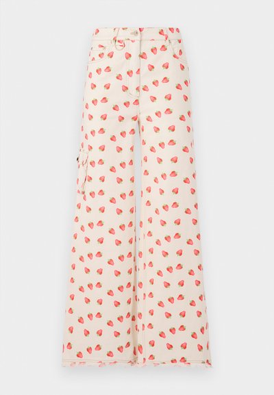 Pantaloni a gamba larga realizzati in un tessuto beige, con un motivo di fragole rosse e verdi. Comprendono tasche laterali e un orlo sfilacciato.