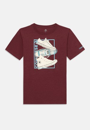 Bordo trumpa rankovė T-marškiniai su grafika, vaizduojančia baltus Converse sportbačius su mėlynomis detalėmis ir užrašu "CONVERSE" stačiakampėje rėmelėje.
