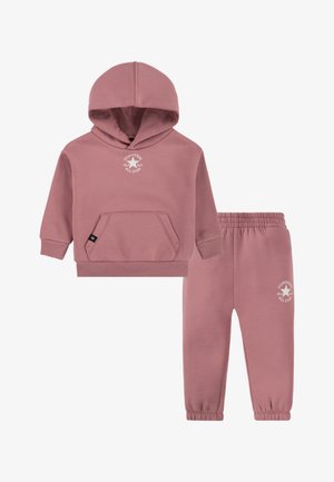 Rosa bomullshettegenser med kengurulomme og hvit logo, kombinert med matchende avsmalnende bukser med elastisk linning.