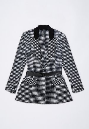 Black and white houndstooth patterned blazer with a black velvet collar, belted waist, and two front pockets. Tailored design, long sleeves.