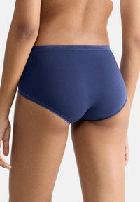 Dunkelblaue Baumwollslips mit glatter Textur, mittelhoher Passform und kontrastierenden Nähten. Der Bund liegt bequem an den Hüften.