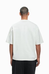 Kurzarm-T-Shirt in Off-White, mit lässiger Passform, rundem Halsausschnitt und schlichtem, strukturiertem Stoff. Rückansicht mit minimalen Details.