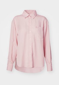 Camicia button-up a maniche lunghe color rosa chiaro con colletto, taschino sul petto e logo ricamato. Realizzata in tessuto di cotone morbido.