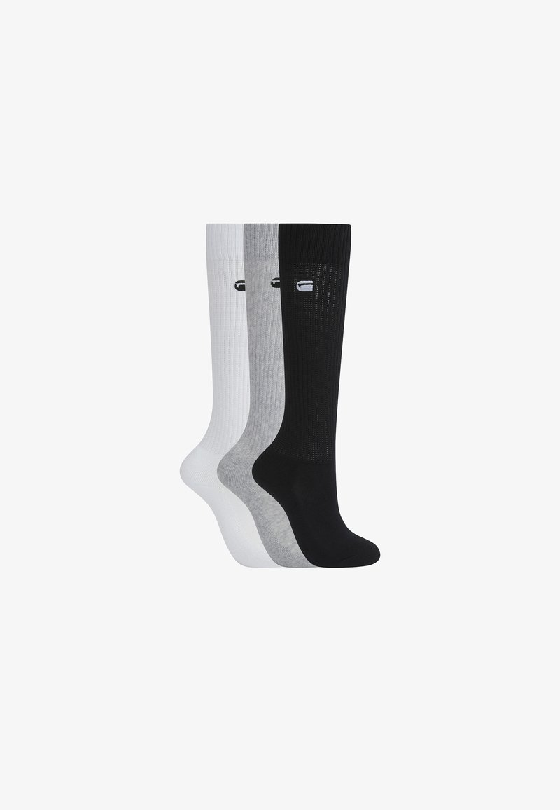 Trois paires de chaussettes hautes côtelées en blanc, gris et noir, chacune avec un petit logo près du haut.