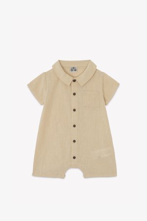 Romper beige de manga corta con cuello tipo camisa, seis botones marrones y un bolsillo en el pecho. Hecho de una tela texturizada y ligera.