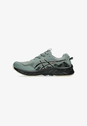 Chaussure de course en vert muted avec des accents noirs, dessus en maille texturée, semelle concave et détails superposés. Fermeture à lacets et col rembourré.