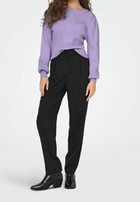 Pull côtelé lilas avec motif texturé, associé à un pantalon noir taille haute et des bottines noires. Matières lisses, coupe ajustée.