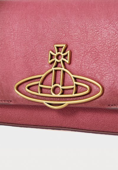Fuchsiahud læderpung med tekstureret overflade, der har et emblem i guldfarvet metal af en globe omgivet af en orbitalring og kors.