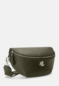 Olivově zelená kožená ledvinka s zakřiveným tvarem, stříbrnými doplňky, zipovým uzavřením a logem vyraženým na přední straně. Součástí je nastavitelný popruh.