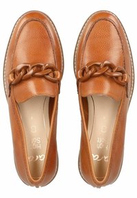 Un paio di mocassini in pelle beige con un grande dettaglio a catena marrone sul davanti e soletti morbidi e imbottiti.