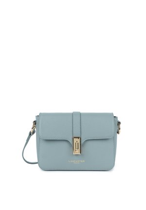 Sac à bandoulière en cuir bleu clair avec fermoir doré et sangle réglable, avec le texte "Lancaster Paris" sur le devant.