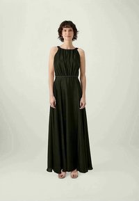 Vestido longo, sem mangas, verde escuro, com corpete franzido, cintura ajustada e saia fluida. Apresenta um brilho subtil e um design minimalista.