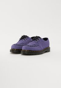 Pantofi din suede purpuriu cu un superior texturat, prezentând perforații decorative, șireturi negre și o talpă groasă neagră cu accente de cusătură galbenă.
