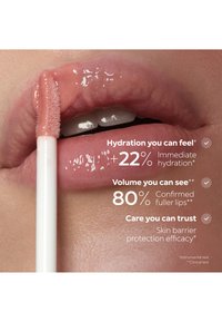 Lèvres brillantes avec un applicateur de gloss appliquant une couleur nude translucide, mettant en avant l’hydratation, un volume plus plein et les bienfaits de la protection de la barrière cutanée.