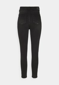 Jean skinny taille haute noirs avec poches arrière et passants de ceinture, présentés sur un fond blanc uni.