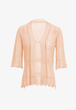 Persikkaisen värinen neule, jossa on neulottu kuvio, lyhyet hihat, aaltoileva helma ja etulukitus hopeanvärisellä soljella.