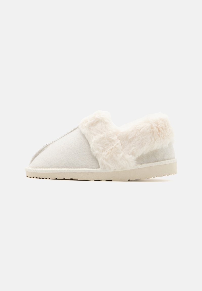 Chinelo branco com um colarinho de pelo sintético suave. Apresenta uma ponta arredondada, parte superior em feltro e uma sola de borracha bege com detalhes antiderrapantes.
