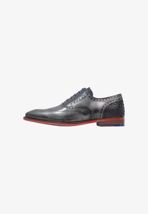 Chaussure habillée en cuir gris avec des détails brogues, des accents texturés bleu foncé, une semelle rouge et un design à pointe. Présente un système de laçage classique.