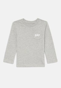 Vaaleanharmaa pitkähihaisen lapsen paita, jossa on pieni etutasku, jossa on valkoiset "GAP"-kirjaimet vasemmalla rinnalla.