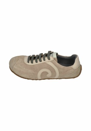 Beige suede sneaker with dark gray laces, cream leather swirl detail on side, low profile, and brown rubber sole.