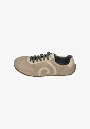 Beige suede sneaker with dark gray laces, cream leather swirl detail on side, low profile, and brown rubber sole.
