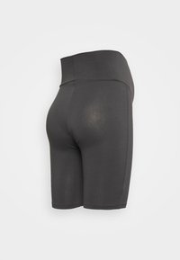 Calças de ciclista de cintura alta em tecido cinza escuro. Textura suave com design ajustado e sem costuras visíveis. O comprimento chega até metade da coxa.