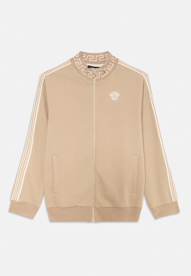 Beige Zip-Jacke mit hohem Kragen, weißen gestreiften Ärmeln und einem griechischen Schlüsselmotiv. Einschließlich Fronttaschen und einem gestickten Logo.