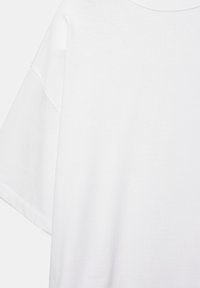 Biele oversized tričko s krátkym rukávom, spustenými rukávmi a okrúhlym výstrihom, zobrazené na jednoliatom pozadí.