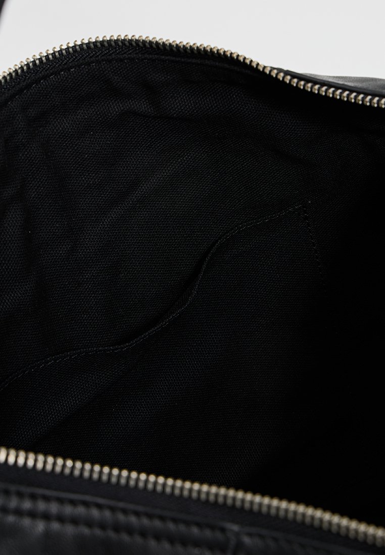 Schwarze Stofftasche mit glatter Innenfläche, ausgestattet mit einem Reißverschluss und einer kleinen Tasche auf einer Seite.