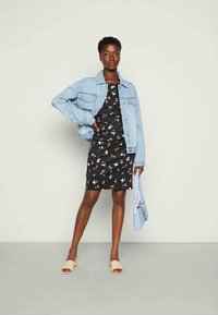 Jaqueta de ganga sobre um vestido preto com padrão floral. Sandálias de dedo bege. Bolsa azul clara. Texturas suaves, cores variadas e designs simples.