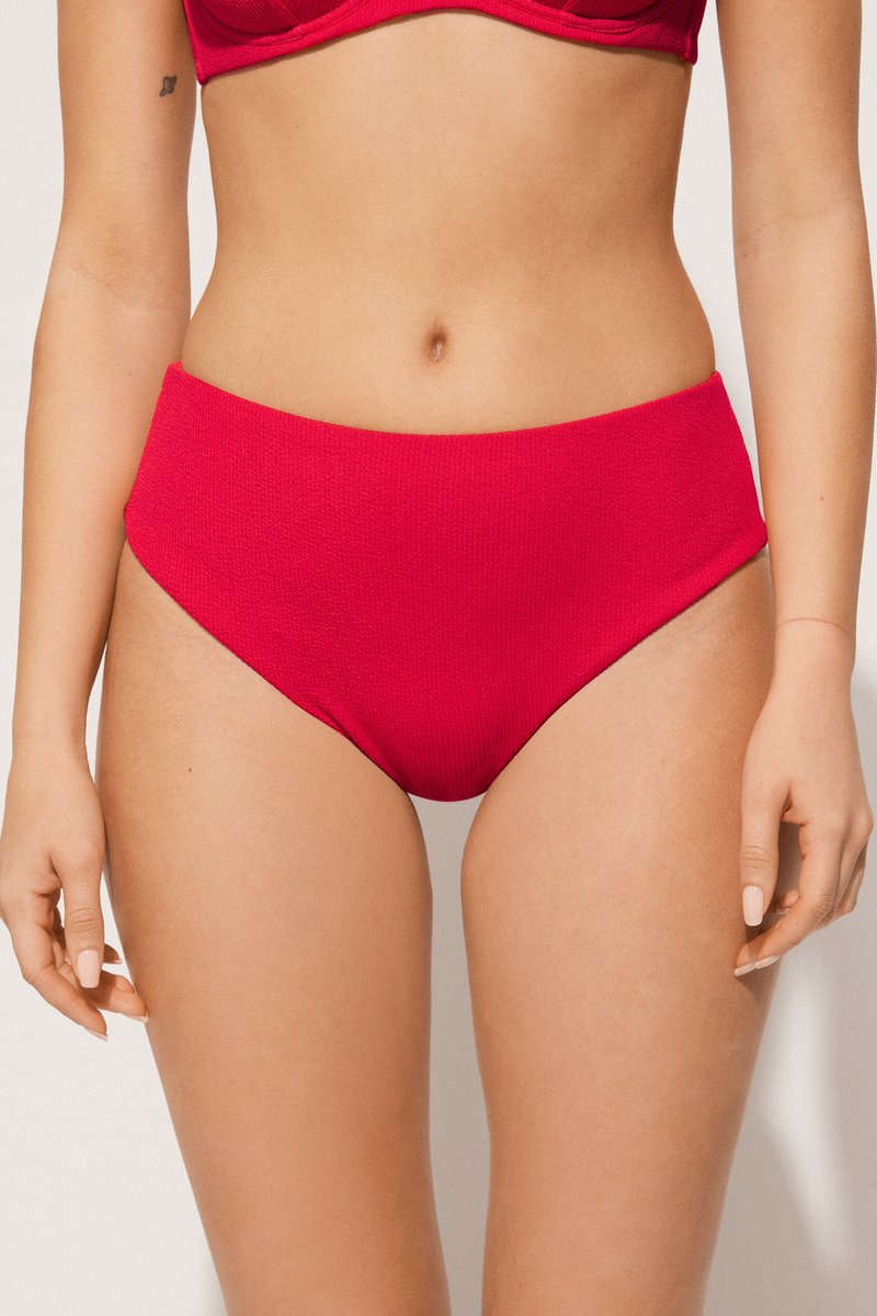 Vysoké bikiny s nízkým pasem ve světlé červené texturované látce, s hladkým pásem a zakřivenými otvory na nohy.