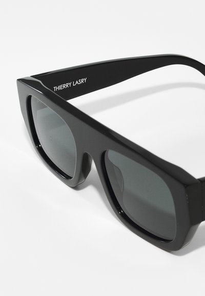 Black sunglasses with a glossy finish, wide rectangular lenses, thick frames, and silver branding on the arm.
