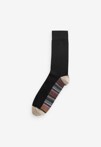 Sort sok med solid overdel, der har et flerfarvet stribet design og en beige tådel. Glat overflade og ankellængde.