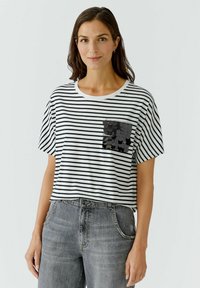 Schwarz-weiß gestreifes T-Shirt mit kurzen Ärmeln, rundem Halsausschnitt und einer schwarzen Pailletten-Patch-Tasche auf der linken Seite.