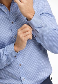 Lichtblauw patroon overhemd met een button-down kraag, kleine geometrische ontwerpen en lange mouwen met knoopsluiting.